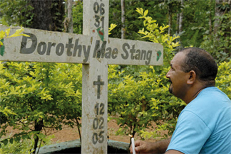 priest praying at grave